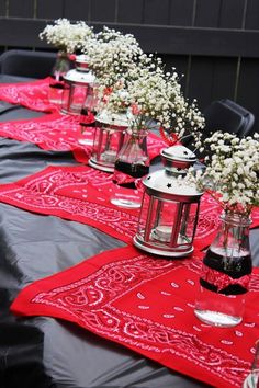 there are many vases with flowers in them sitting on the table cloth that is laid out