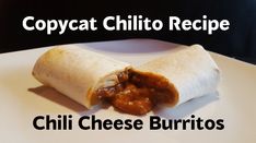 a burrito on a white plate with chili cheese burritos in the middle