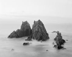 black and white photograph of rocks in the ocean