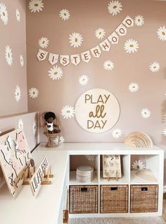 a playroom is decorated with white daisies on the wall and wooden letters that spell out sisterhood