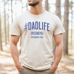 Let the world know that fatherhood is just around the corner with this personalized pregnancy announcement t-shirt for the soon-to-be dad in your life! This shirt features the hashtag #dadlife and can be customized with the expected due date for a unique touch. Made from high-quality materials, this shirt is both comfortable and durable, making it a great gift for any new dad. This classic unisex jersey short sleeve tee fits like a well-loved favorite. Soft cotton and quality print make users fall in love with it over and over again. These t-shirts have-ribbed knit collars to bolster shaping. The shoulders have taping for better fit over time. Dual side seams hold the garment's shape for longer.  .: 100% Airlume combed and ringspun cotton (fiber content may vary for different colors) .: Li Pregnancy Surprise, Pregnancy Announcement Shirt, Due Date, Dad Life, Baby On The Way, New Dads, Family Matching, Cricut Explore, Dad To Be Shirts