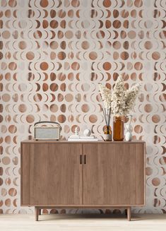 a wooden cabinet sitting in front of a wall with circles on it