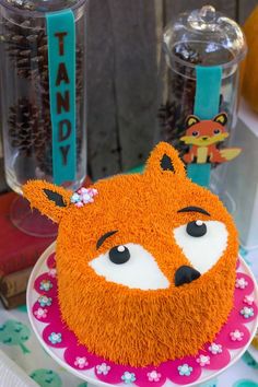 there is a cake that looks like a fox on top of a table with other decorations