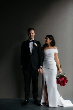 a man and woman in formal wear standing next to each other with flowers on their feet