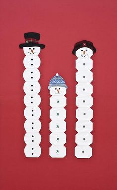 two snowmen are standing next to each other on a red background, one is wearing a hat