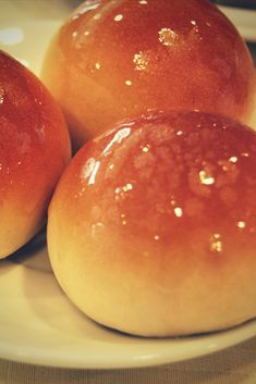 three round bread rolls on a white plate