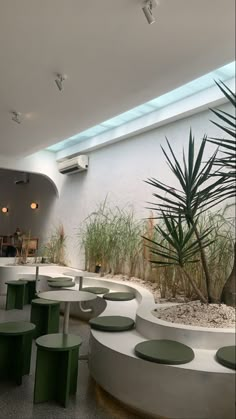 an indoor seating area with green and white benches