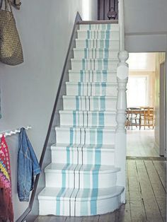 there is a blue and white stair case on the wall next to the banister