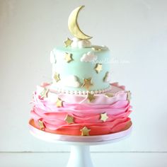 a three tiered cake with stars and a moon on top