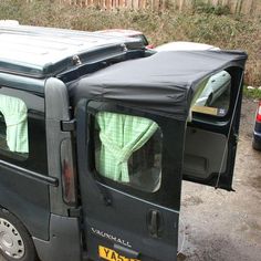 the back end of a van with its doors open and towels hanging from it's roof