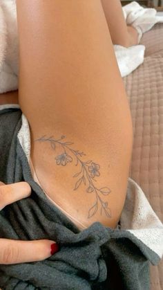 a woman's hand on the back of her leg with flowers drawn on it