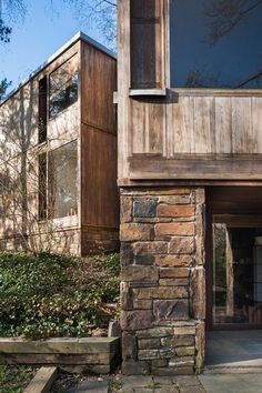 an outside view of a house with stone and wood