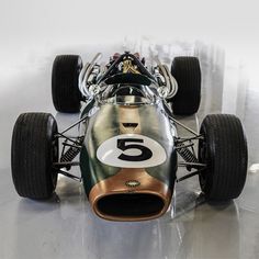 an old fashioned race car is on display in a showroom with shiny flooring