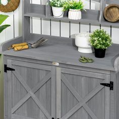 a gray cabinet with plants and scissors on top