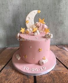 a pink cake with stars and a teddy bear on top