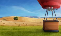 a hot air balloon in the middle of a field with bales of hay behind it