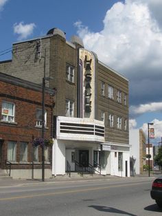 an old movie theater sits on the corner of a street in front of a brick building