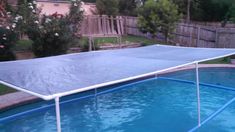 an above ground swimming pool with a cover over the bottom and some water around it