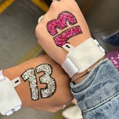 two girls with tattoos on their arms and one has the number thirteen painted on her arm