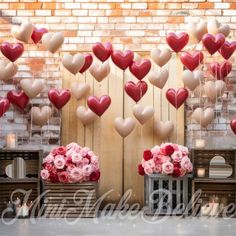 valentine's day decorations with heart balloons and flowers on display in front of a brick wall