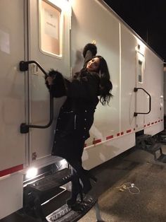 a woman standing on the side of a white trailer