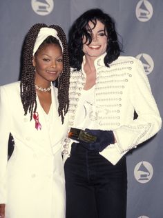 two women standing next to each other on a red carpet