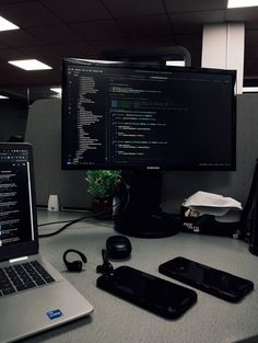 a laptop computer sitting on top of a desk next to a phone and other electronics