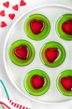 heart shaped jello shots on a plate with candy canes in the shape of hearts