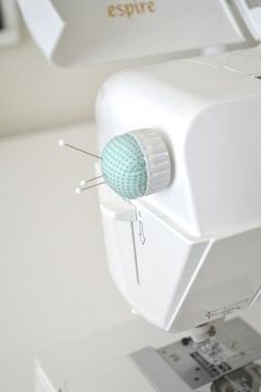 a sewing machine with a blue ball on it's head and thread in the middle