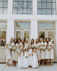 a group of women standing next to each other in front of a building with windows