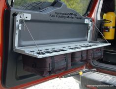 the back end of a red truck with its cargo compartment open