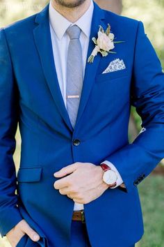 a man in a blue suit with a flower boutonniere on his lapel