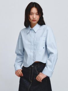 This is a cropped shirt featuring a breezy length and an asymmetric curved hemline. The relaxed sleeve silhouette creates a sophisticated body fit, and the front pocket detail and signature embroidery add points. Made of high-density premium cotton material with a luxurious appearance.- Square pocket on the chest- Easy to move around thanks to the tuck on the back- Open and close with round buttons- A highly versatile item that can be worn alone as well as layered with various innerwear.*The color of the product may differ from the actual color depending on the monitor resolution. Spring Cropped Shirt With Pockets, Chic Cropped Shirt With Cropped Hem For Spring, Trendy Cropped Shirt For Spring, Casual Relaxed Fit Cropped Shirt, Spring Workwear Tops With Cropped Hem, Chic Cropped Shirt With Pockets, Chic Cropped Shirt With Pockets For Spring, Cropped Spring Blouse With Pockets, Spring Cropped Blouse With Pockets