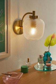 a bathroom with a sink, mirror and lamp on the wall next to each other