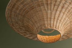 a wicker basket hanging from the ceiling with a circular light fixture in front of it