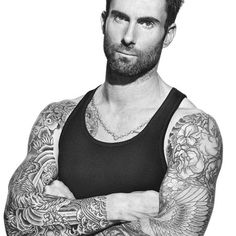 a black and white photo of a man with tattoos on his arms, wearing a tank top