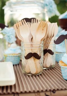 wooden utensils with fake mustaches in mason jars on top of a table