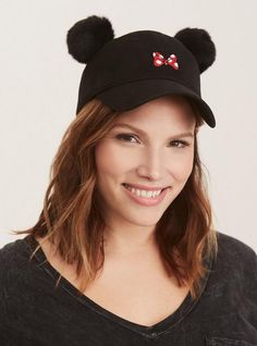 a woman wearing a black hat with minnie mouse ears on it's brim