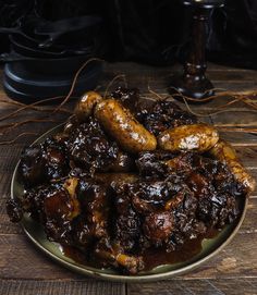 a plate full of cooked sausages on a wooden table next to a black lamp