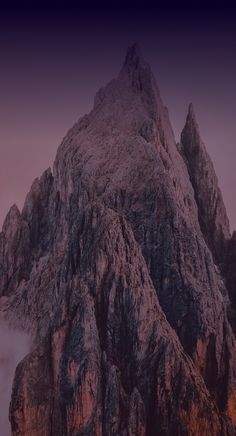 the top of a mountain is covered in fog