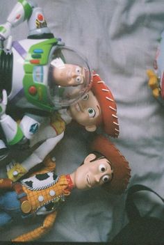 toy story figures laying on top of a bed