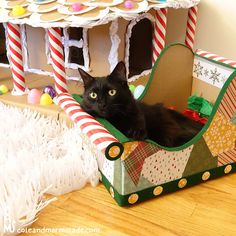 a black cat is sitting in a christmas sleigh