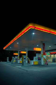 an empty gas station at night with the lights on