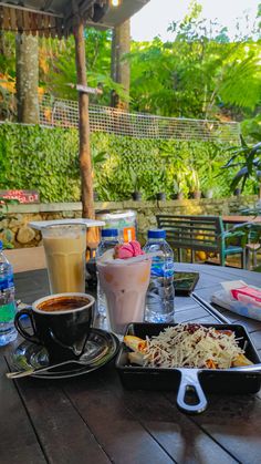 a table topped with plates of food and drinks next to each other on top of a wooden table