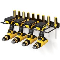 a bunch of yellow and black tools hanging from a rack on a white wall with screwdrivers attached to it