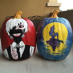 two painted pumpkins sitting next to each other