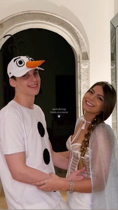 a young man and woman dressed up as frozen world characters in front of an open door