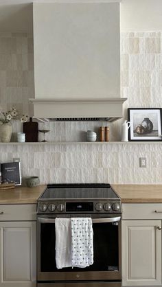 a stove top oven sitting inside of a kitchen next to a wall mounted range hood