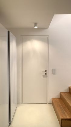 a white door and some stairs in a room