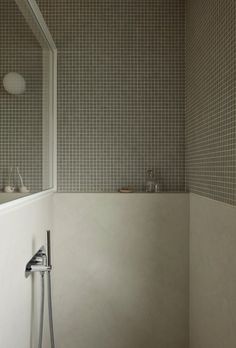 a bath room with a toilet and a shower head mounted to the side of a wall